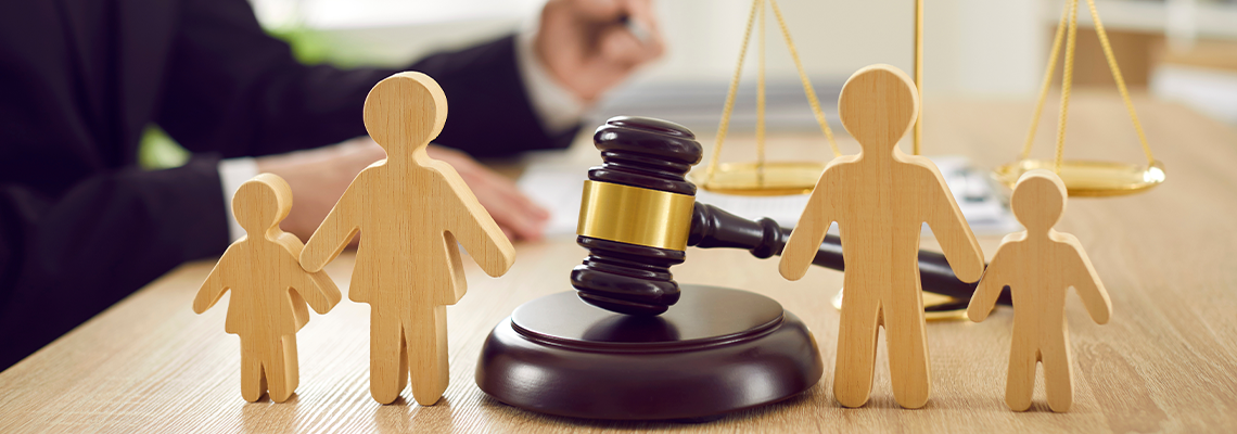 Gavel, sound block and little wooden figures of parents and children