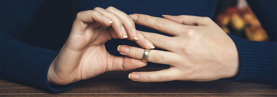 Women removing wedding ring from hand