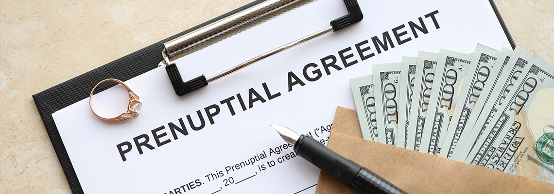 Prenuptial agreement and wedding ring on table